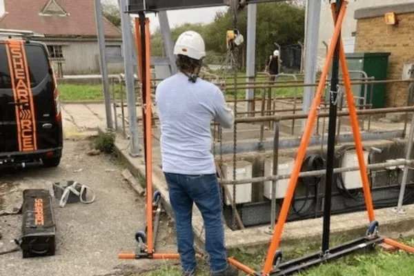 A construction worker exploring the advantages of using an aluminium gantry on a construction site to lift heavy weights.